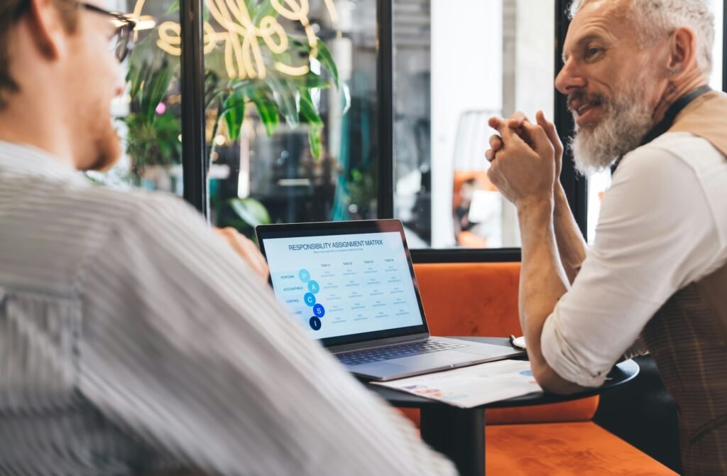 corporate directors with digital laptop computer discussing trade marketing